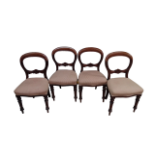 A set of four mahogany balloon back chairs - with stuffover seats and turned tapering legs.