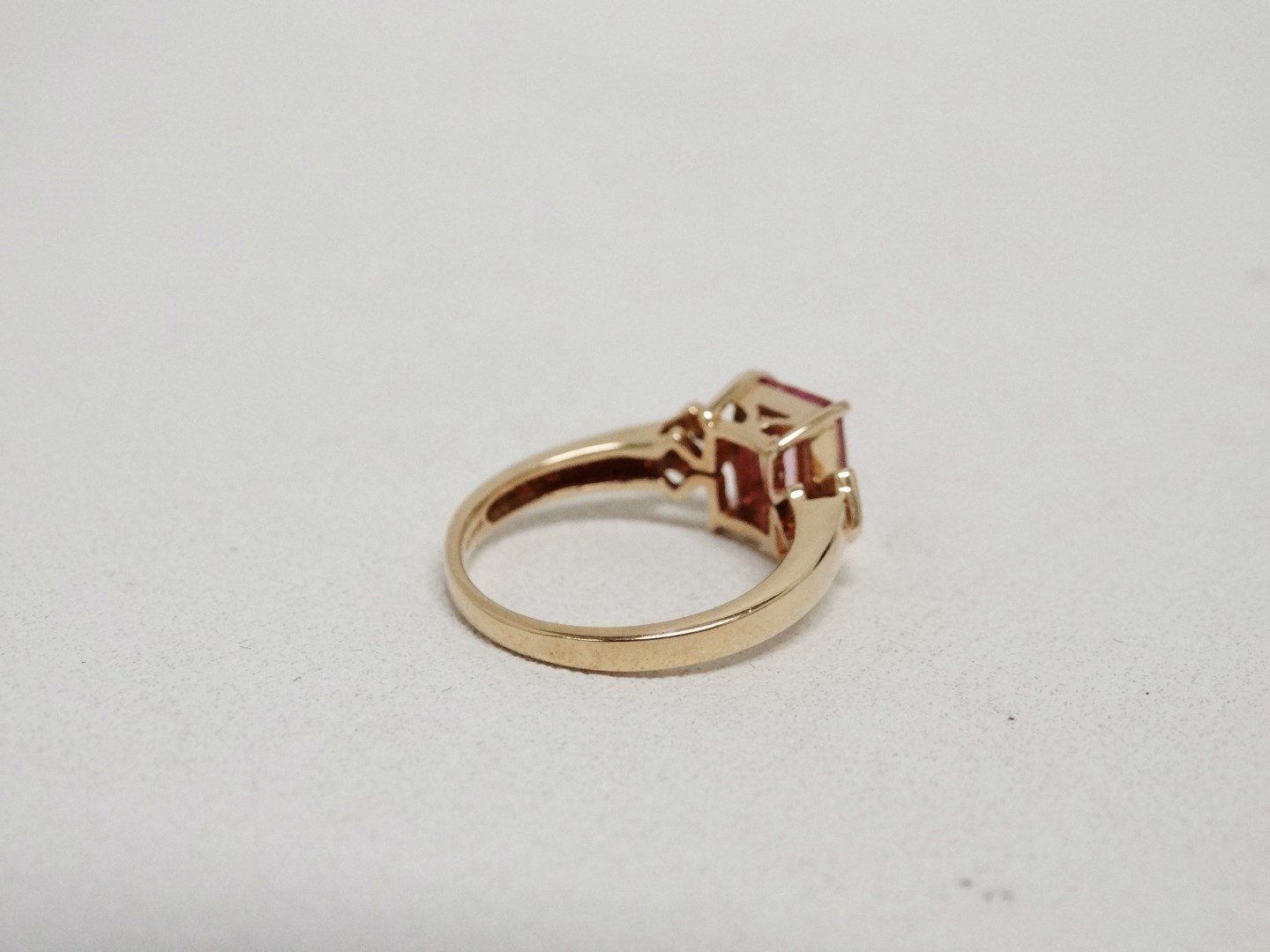 A pink tourmaline and diamond dress ring - the emerald cut central stone flanked by diamonds on a - Image 4 of 5