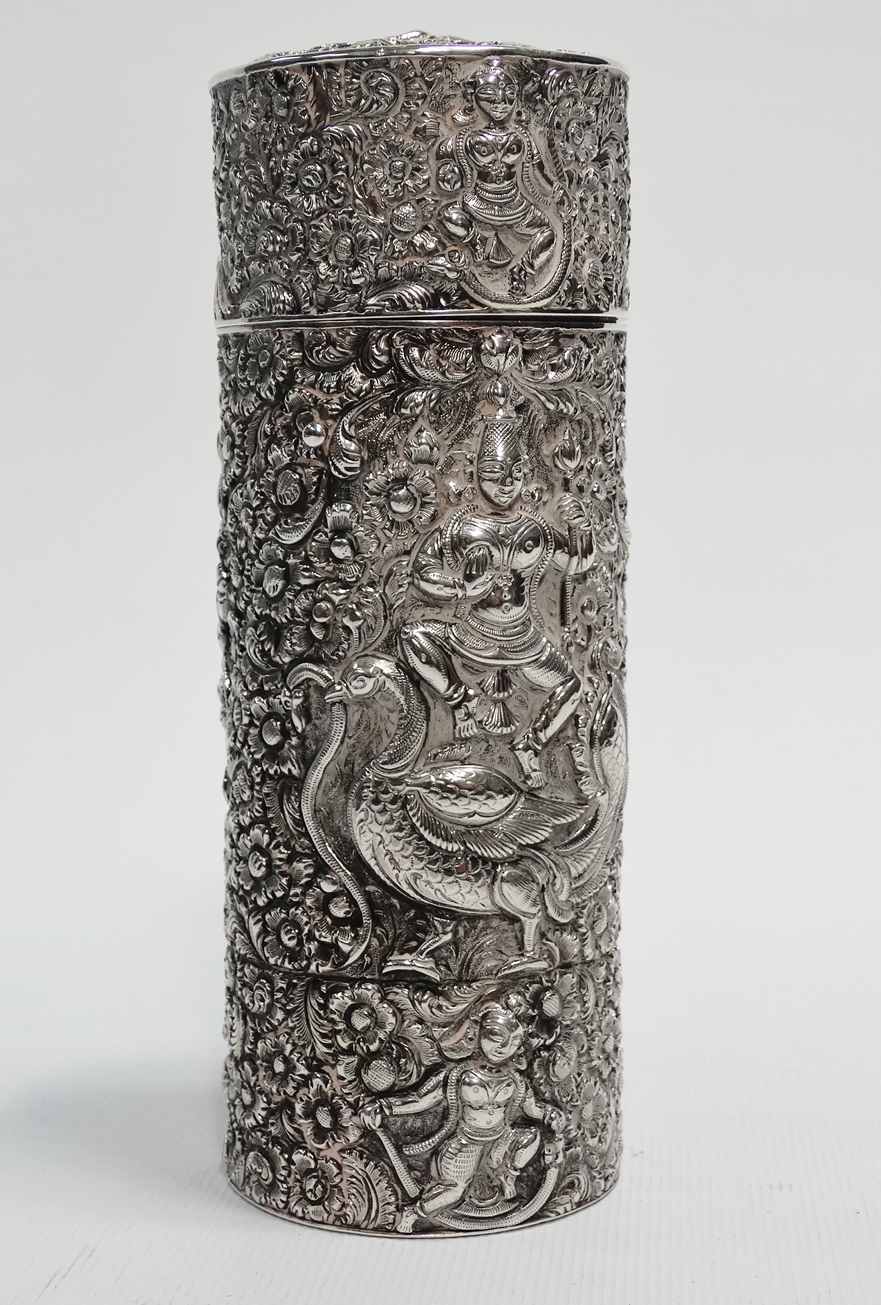 An Indonesian silver cylindrical scribes box - Extensively decorated with figures and birds on a
