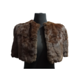 A ladies fur shrug - with a chocolate brown silk lining, length 33cm.