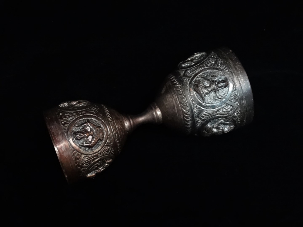 An Indian silver double egg cup - Repousse decorated with deities, 10cm (high), together with a pair - Image 4 of 7