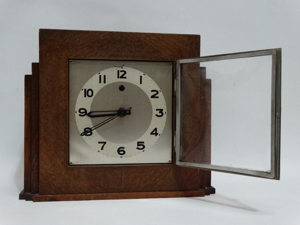 An oak cased Art Deco style mantel clock - the silvered square dial set out with Arabic numerals