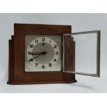 An oak cased Art Deco style mantel clock - the silvered square dial set out with Arabic numerals