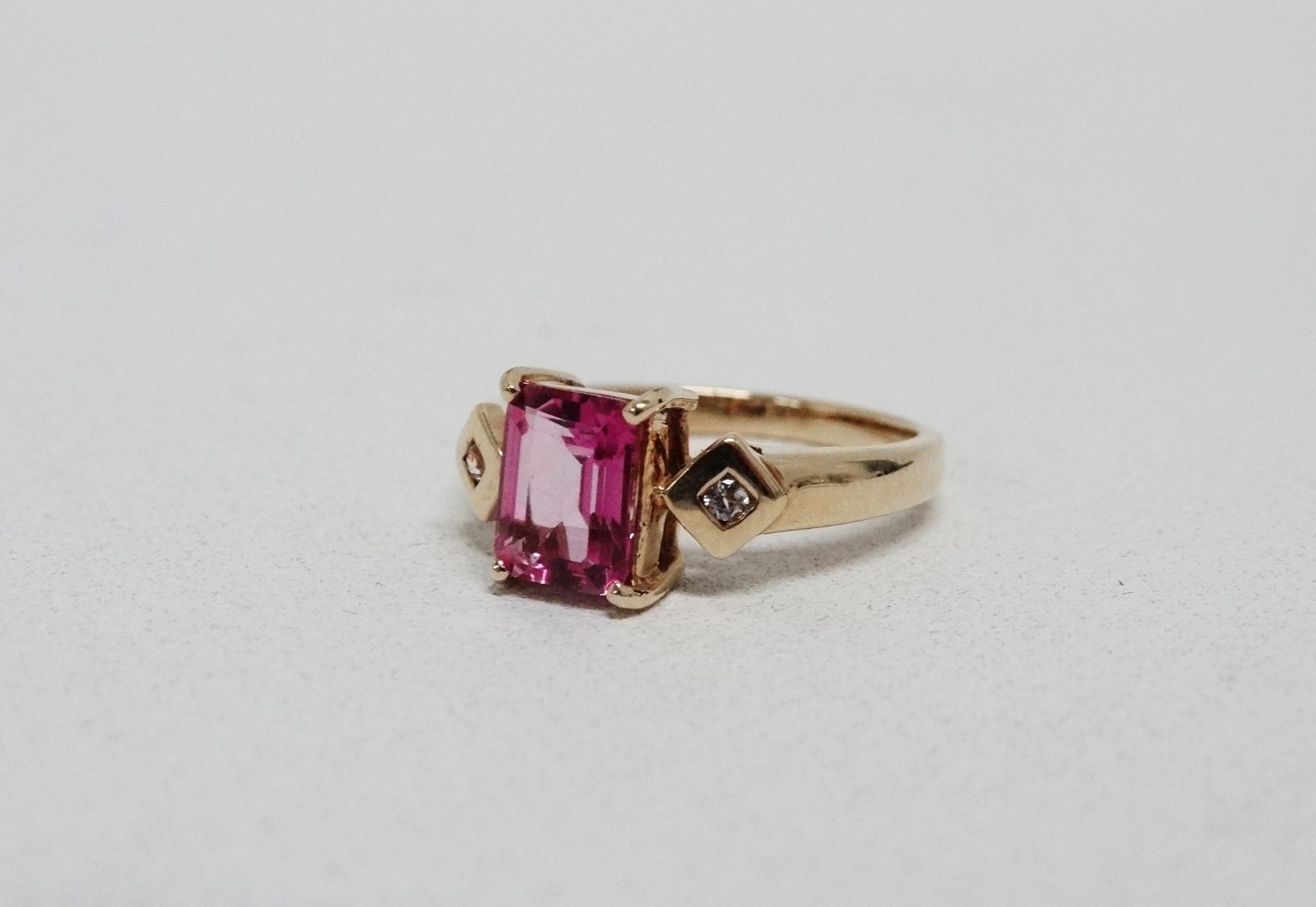 A pink tourmaline and diamond dress ring - the emerald cut central stone flanked by diamonds on a - Image 5 of 5