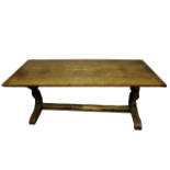 A 17th century style oak refectory table - the cleated rectangular plank top above turned end