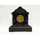 A late Victorian black slate mantel clock - with green marble details, Egyptian masks and cherubs