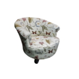 A late Victorian upholstered tub chair - with low back and scrolling arms, raised on short turned