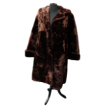 A ladies fur coat - with buttoned cuffs and chocolate brown silk lining, length 100cm, possibly size