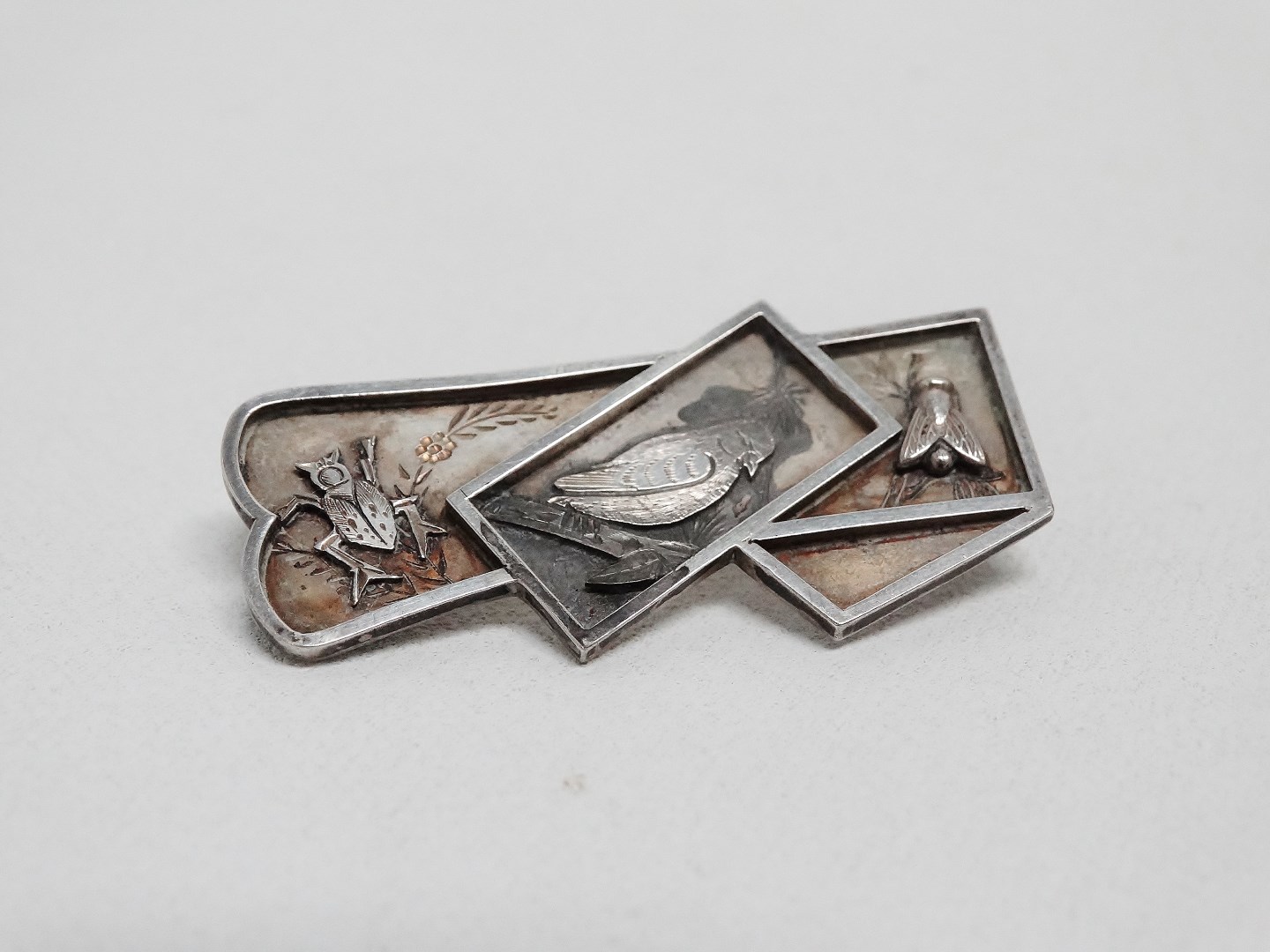 An early 20th century white metal brooch - depicting a dove, a beetle and a fly, weight 8g.