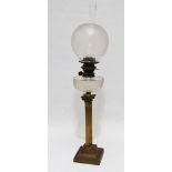 A Victorian brass oil lamp - the clear cut glass reservoir and etched glass globe, on a brass