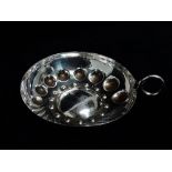 A continental white metal wine taster - with repousee decoration and a ring handle, diameter 8cm,