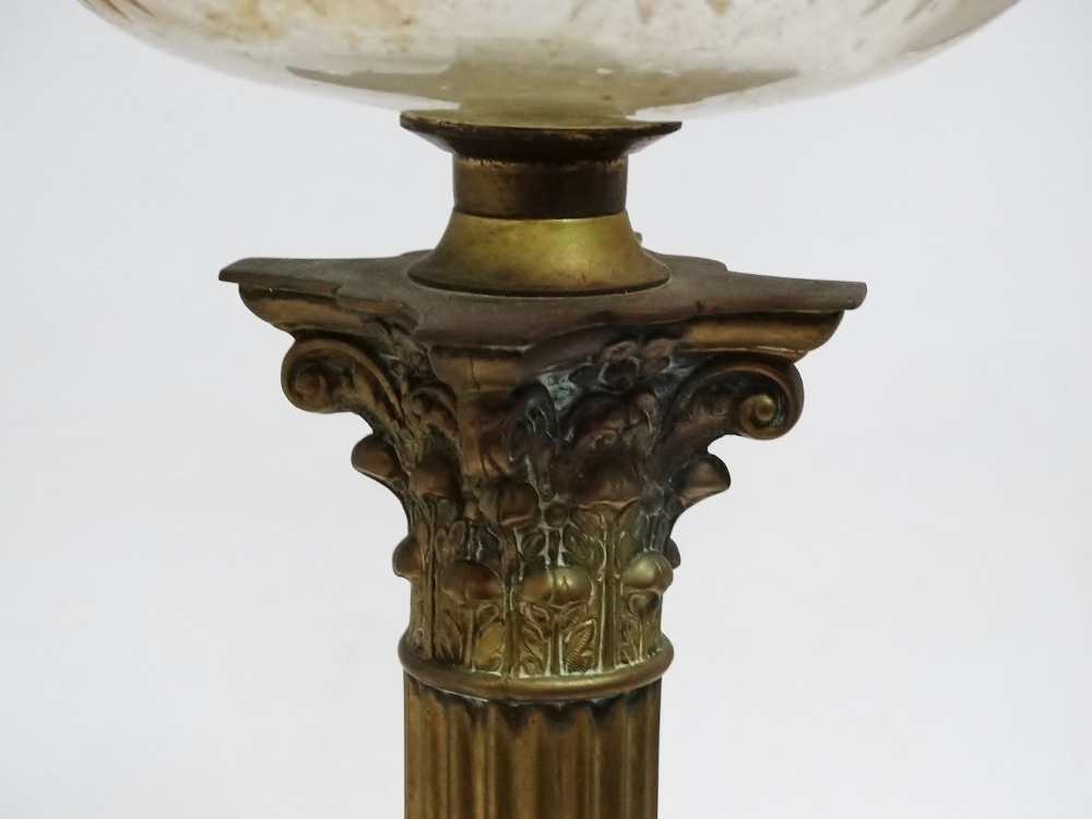 A Victorian brass oil lamp - the clear cut glass reservoir and etched glass globe, on a brass - Image 2 of 4