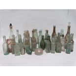 A quantity of late 19th and early 20th century clear glass bottles - including Dennifords & Son of