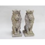 A pair of lion finials - reconstituted stone, the crowned beasts seated on a rectangular base,