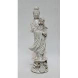 Early 20th century Chinese blanc de chine figure - standing holding a lotus flower, on a circular