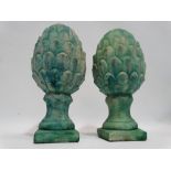 A pair of pineapple finials - reconstituted stone with a Verdigris finish, on square bases, height
