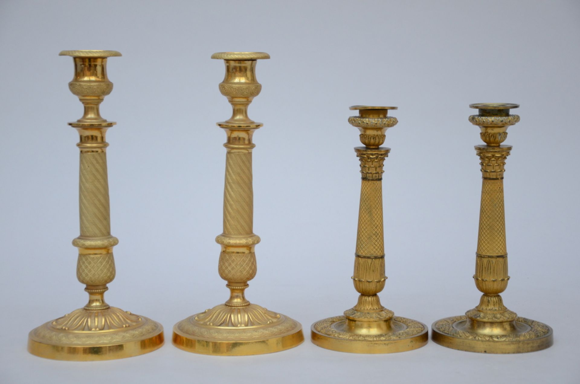 Two pairs of Charles X candlesticks in bronze (h23 and h28cm)