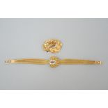 Watch in yellow gold 1960s (18 kt) + brooch in yellow gold 'plume' (18kt)