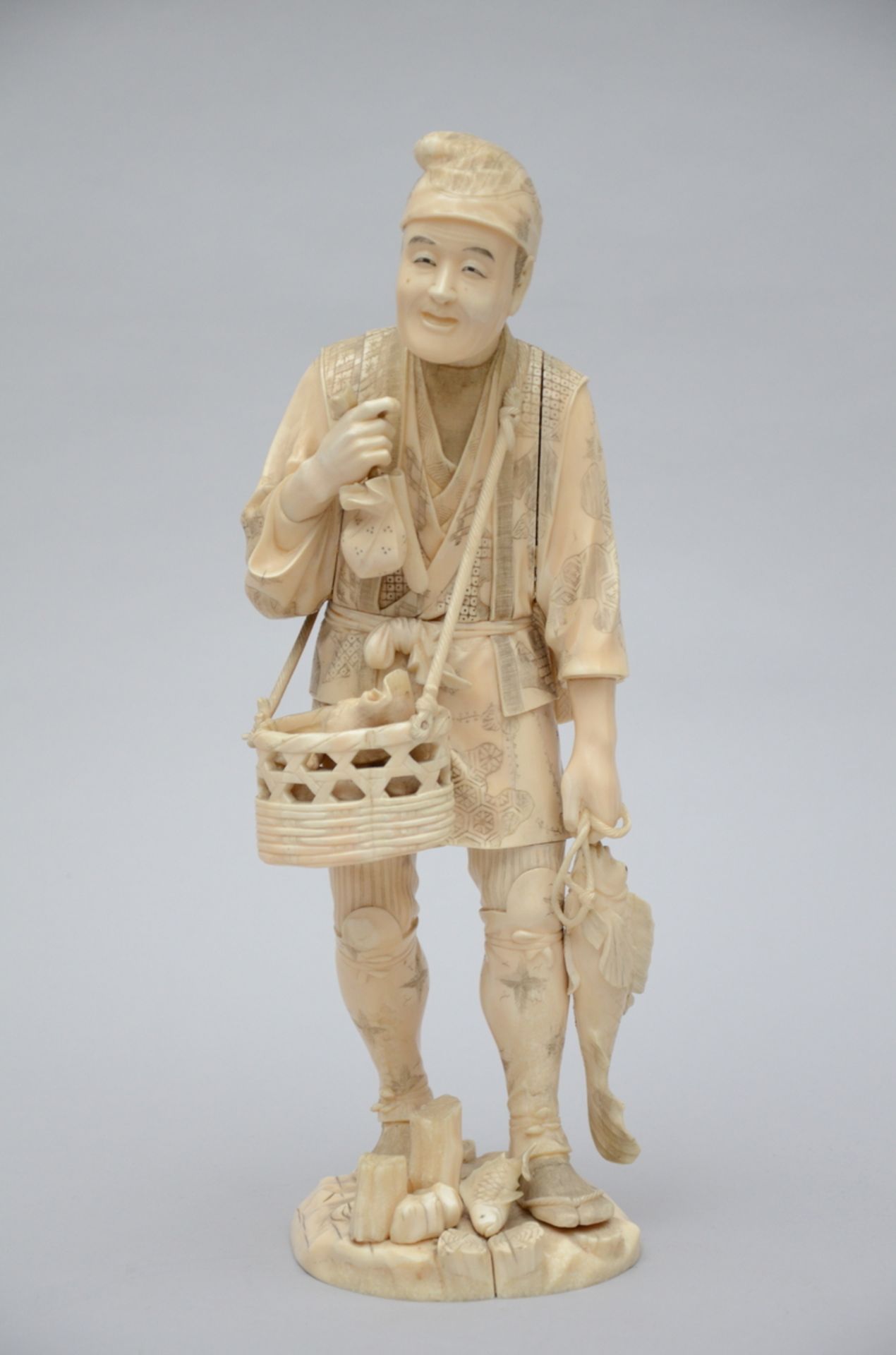 A large Japanese ivory okimono 'fisher', 19th century (marked) (H41)