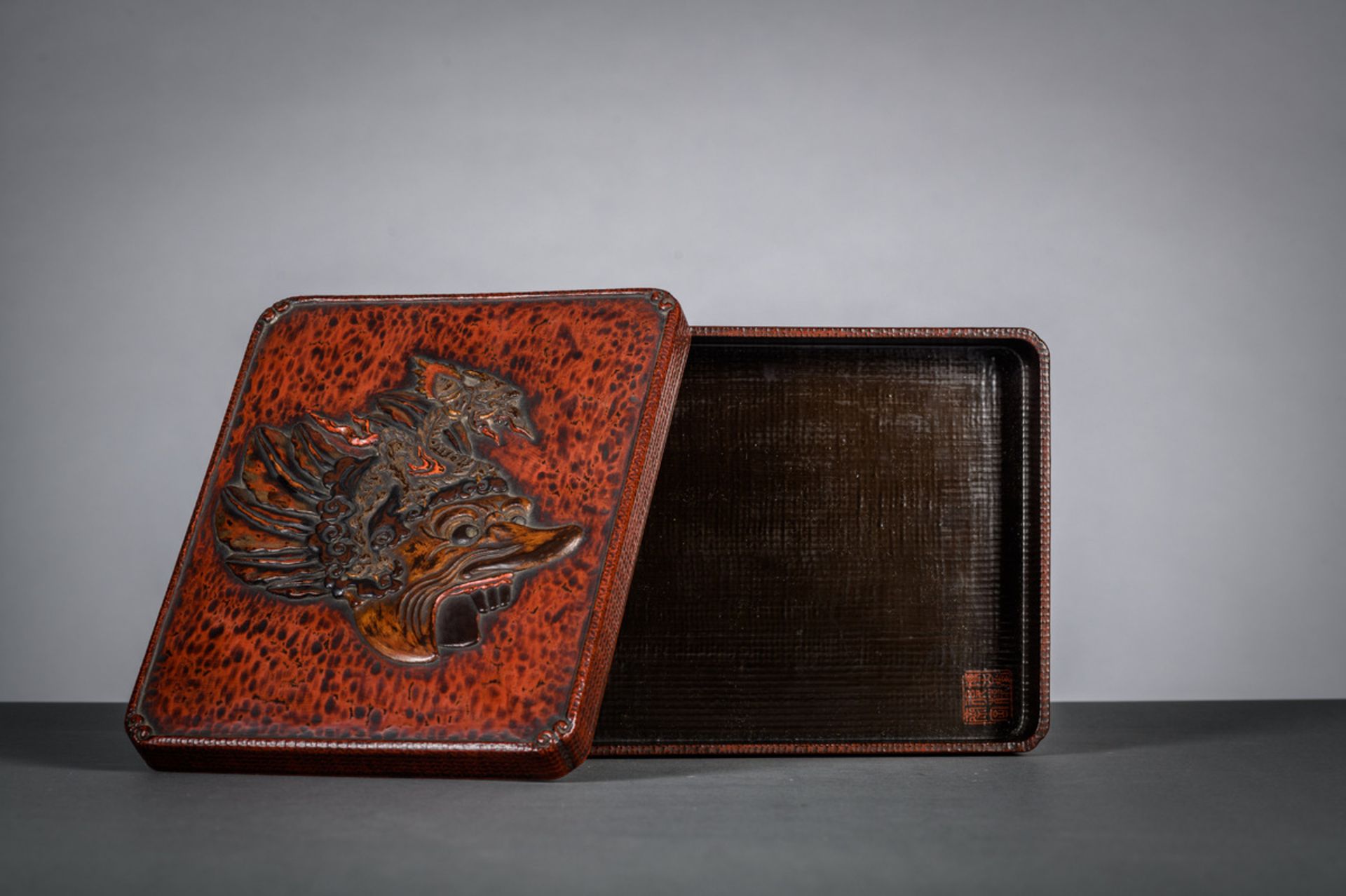 A Japanese red lacquer box with 'demon mask' (19.5x24.5cm)