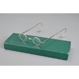 A pair of vintage / antique small framed optical magnifying spectacles with long flexible temples.