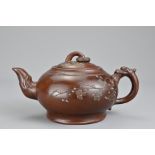 A Chinese vintage Yixing pottery teapot with dragon form handle. The body and cover with raised