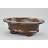 A Chinese oval form bronze censer on four rounded feet. The base with raised three-character mark.