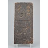 A Chinese compressed tea-brick, circa 1900. The rectangular tea brick with raised Chinese characters