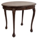 An early 20th Century ovular hardwood occasional table with ornate carving and ball and claw feet.