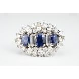 A platinum, diamond & sapphire dress ring. Three oval cut sapphires surrounded by six baguette,