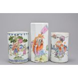 Three Chinese cylindrical porcelain pots. One with eight lobed sides decorated with Scholar figures.
