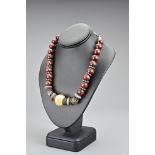 A vintage East Asian wooden bead necklace with metal clasp and spacers with central floral carved