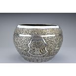 A large Asian white metal repoussé bowl. The rounded bowl decorated with scrolling foliage with four