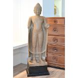 A LARGE Southeast Asian carved stone standing figure of Buddha, Cambodian, Khmer style. Mounted on a