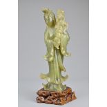 A Chinese early 20th Century carved jade figure of Guanyin mounted on soapstone stand. 29cm tall
