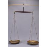 A large set of hanging brass bowl scales with wooden beam on metal chains. Wooden beam length