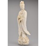 A Chinese Blanc de Chine porcelain figure of Guanyin. The figure standing on a lotus base with