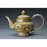 A Tibetan gilt metal teapot/ewer and cover. The body with raised decoration of dragons and