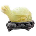 A CHINESE CARVED GLASS BOX AND COVER. In the form of a 'dragon turtle' on carved wooden stand.