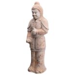 A CHINESE PAINTED POTTERY FIGURE OF A WARRIOR, TANG DYNASTY (618-907). The figure stood with clasped