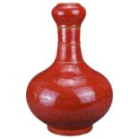 A CHINESE CORAL-GROUND 'GARLIC-MOUTH' VASE. The vase with bulbous body and bamboo form neck