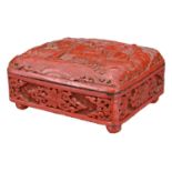 A CHINESE RED LACQUER AND ENAMEL BOX. The rectangular box with hinged cover carved in relief with