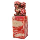 A CHINESE SOAPSTONE SEAL. Surmounted by a mythical beast with cub and carved inscription. Six-