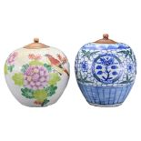 TWO CHINESE PORCELAIN JARS WITH WOODEN COVERS, 19/20TH CENTURY. The first decorated in polychrome