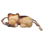 A CHINESE JADE WATER BUFFALO PENDANT. Carved with its legs tucked under its body, resting its