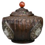 A TIBETAN COPPER REPOUSSÉ BOX AND COVER. The rounded lotus form body with jade 'dragon' emblems on