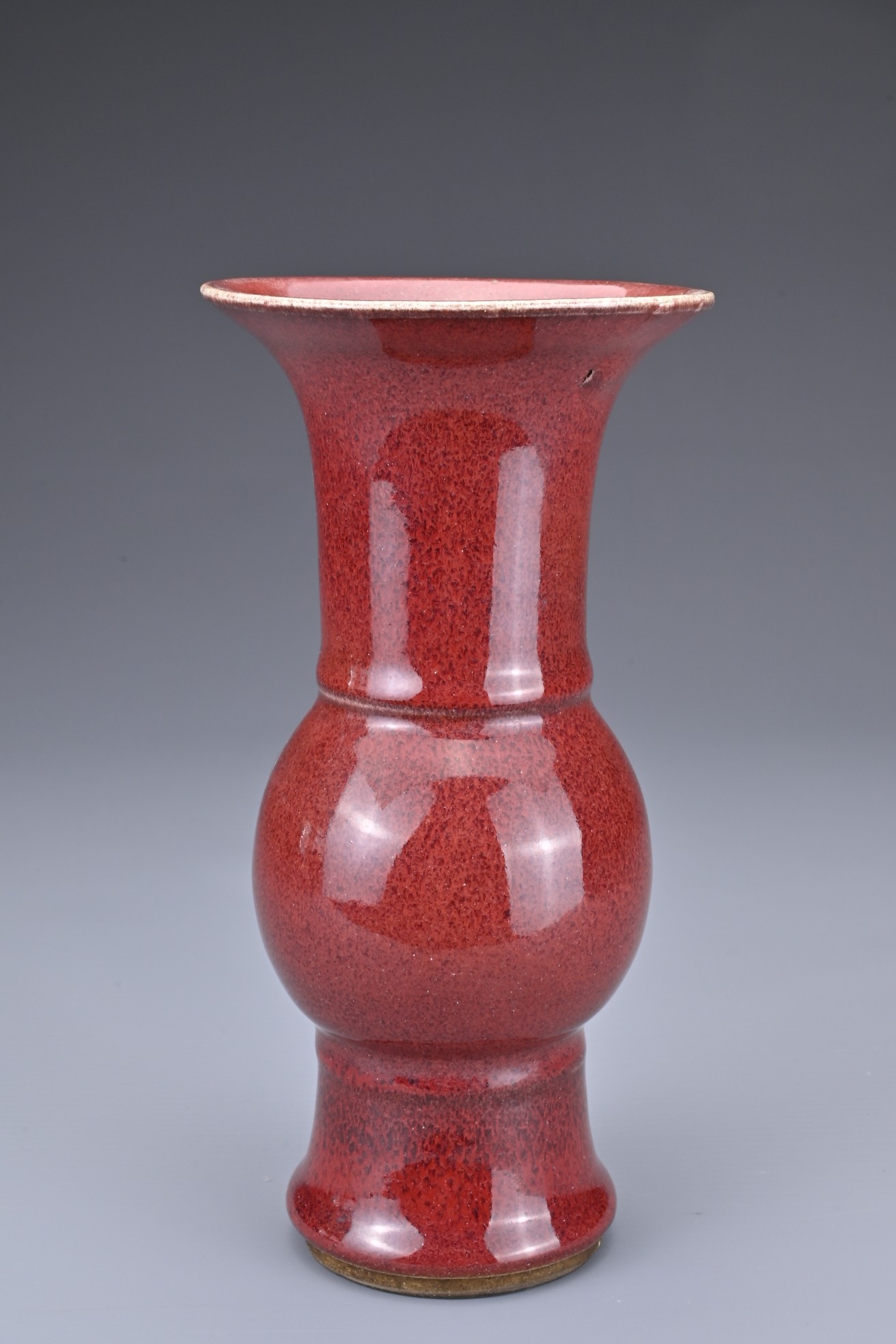 A CHINESE SANG-DE-BOEUF PORCELAIN GU-FORM BEAKER VASE. Covered in a dark red speckled glaze thinning - Image 2 of 7