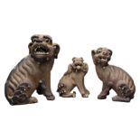 THREE CHINESE SHIWAN POTTERY LION DOGS, LATE QING DYNASTY. Of graduating sizes. 8cm - 13.5cm heights