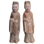 PAIR OF CHINESE PAINTED POTTERY ATTENDANTS, TANG DYNASTY (618-907). Both figures dressed in robes