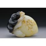 A CHINESE PALE CELADON AND BLACK JADE PENDANT OF MONKEY ON PEACH